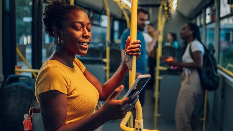 Woman using phone on bus