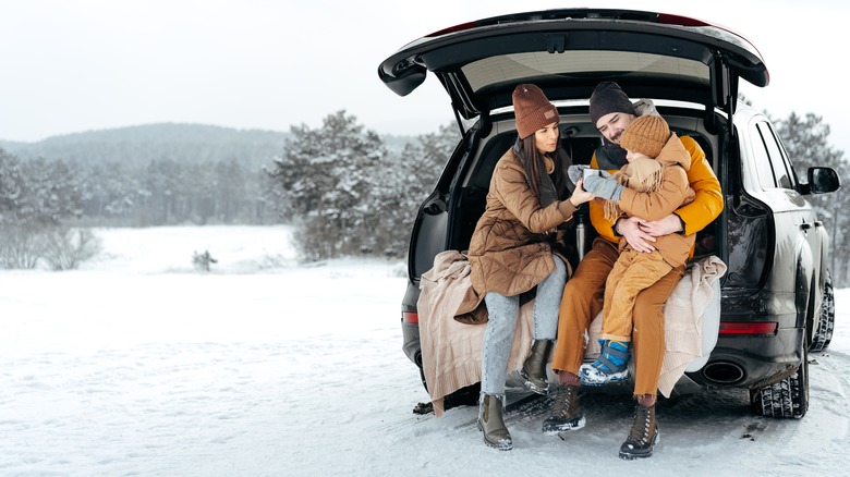 Family sitting in car trunk