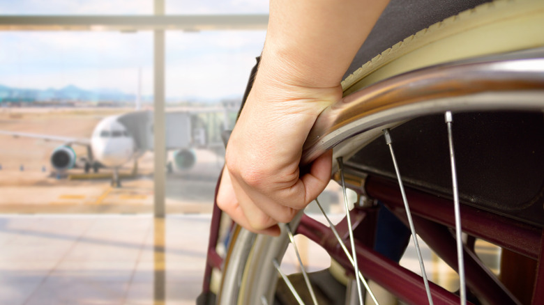 wheelchair user in front of airplane