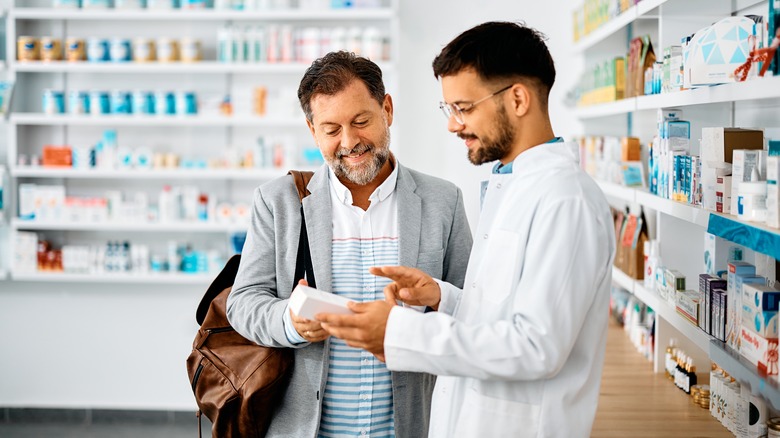 Men in pharmacy looking at drugs