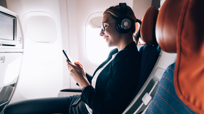 woman using phone on airplane