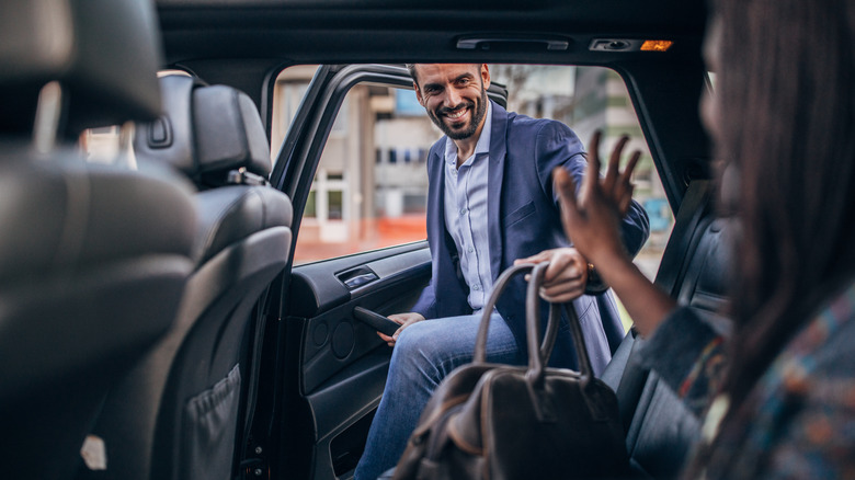 man getting in car backseat