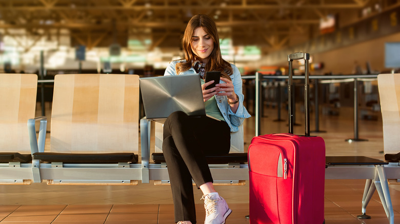 woman with red luggage and computer