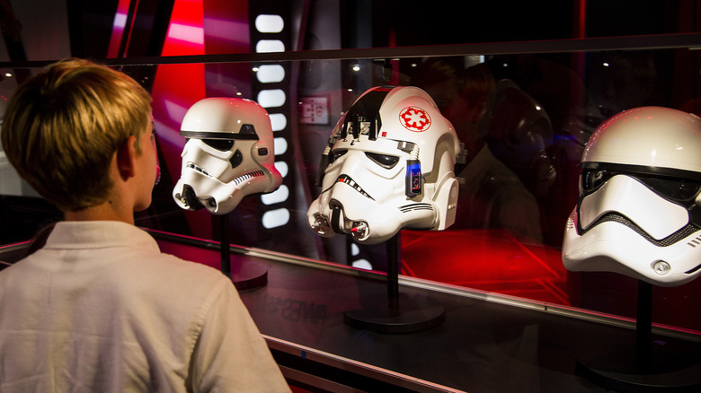 Boy looks at Stormtrooper helmets