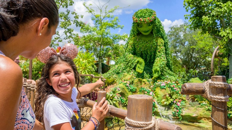 girl smiling at Moana sculpture