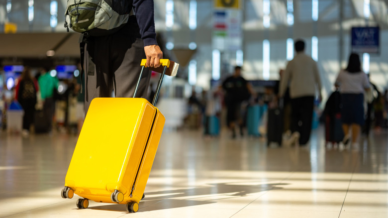 person pulling suitcase in airport