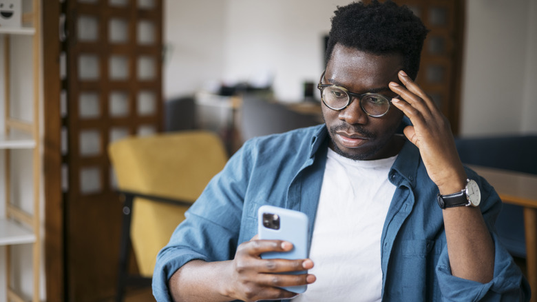 stressed man looking at phone