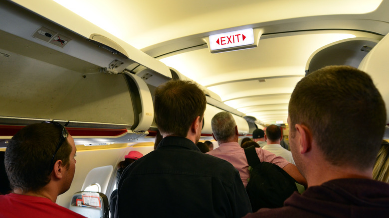 crowded passengers exiting aircraft 
