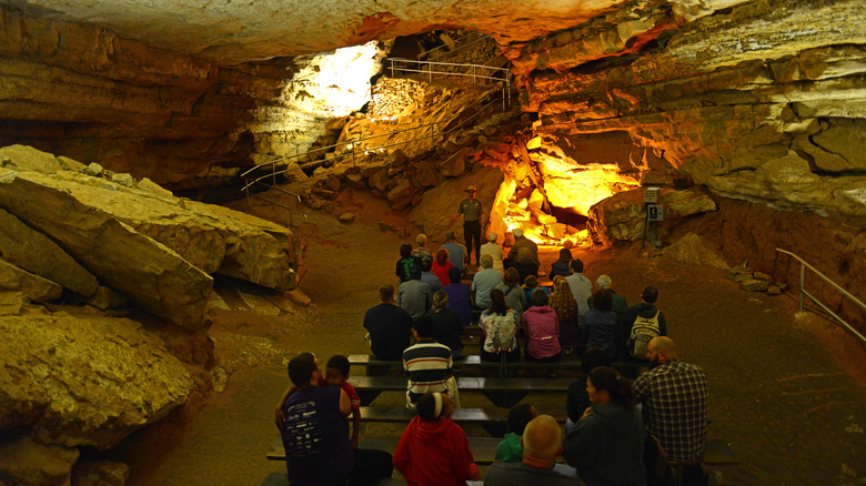 People seated in a large cave area
