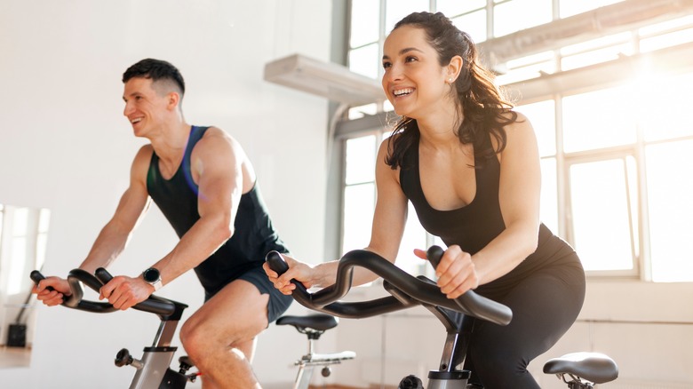 Two people on stationary bikes