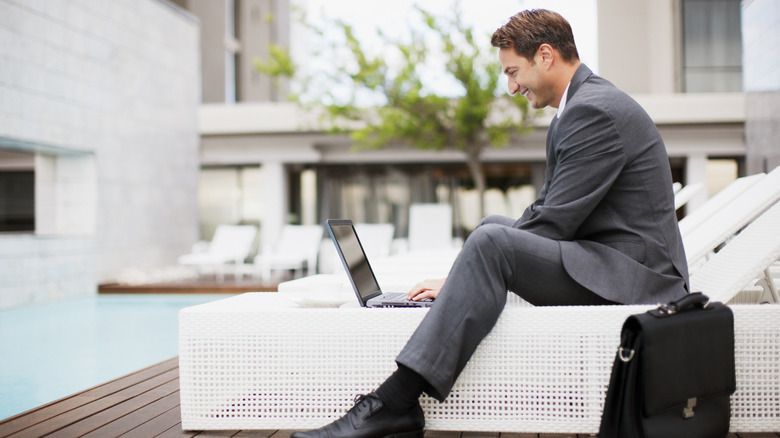 Man sits by hotel pool