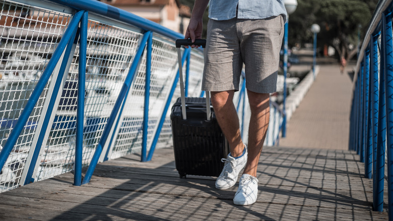 Man bringing suitcase on cruise