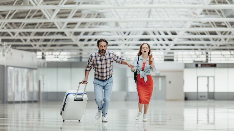 man and woman running through airport