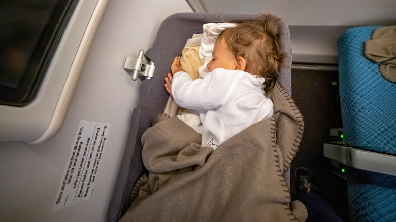 baby sleeping in airplane bassinet