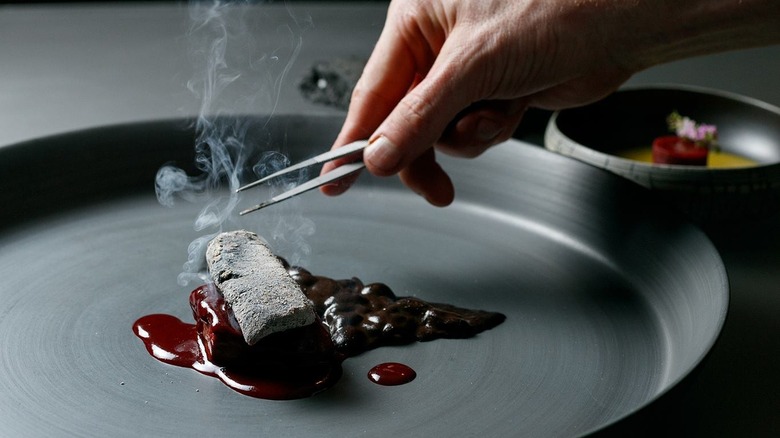 Chef preparing dish at Alinea