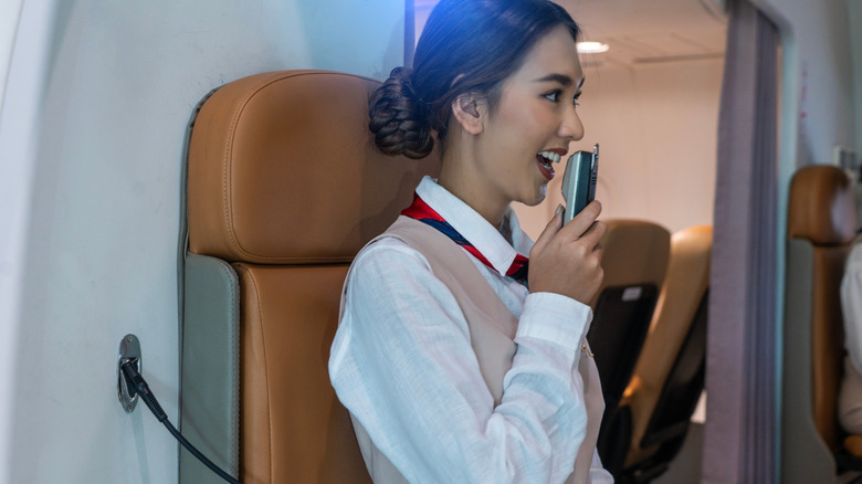 Flight attendant making an announcement over a PA system