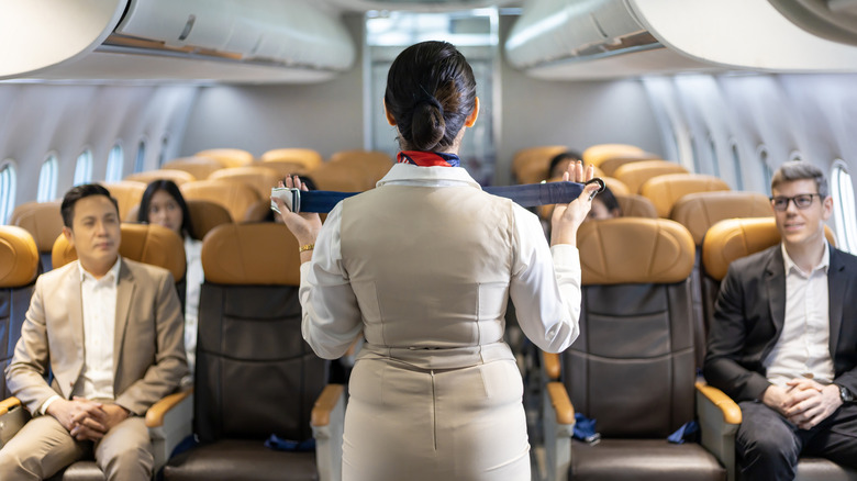 Flight attendant doing a safety demonstration