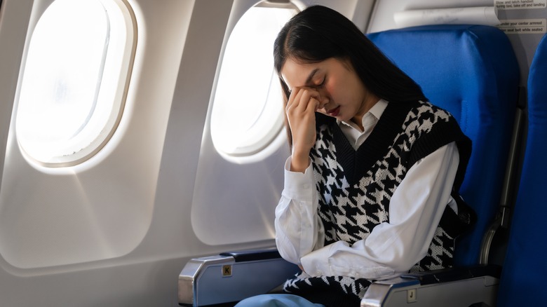 Woman feeling nauseous on plane 