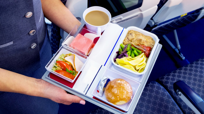 Flight attendant serving a meal