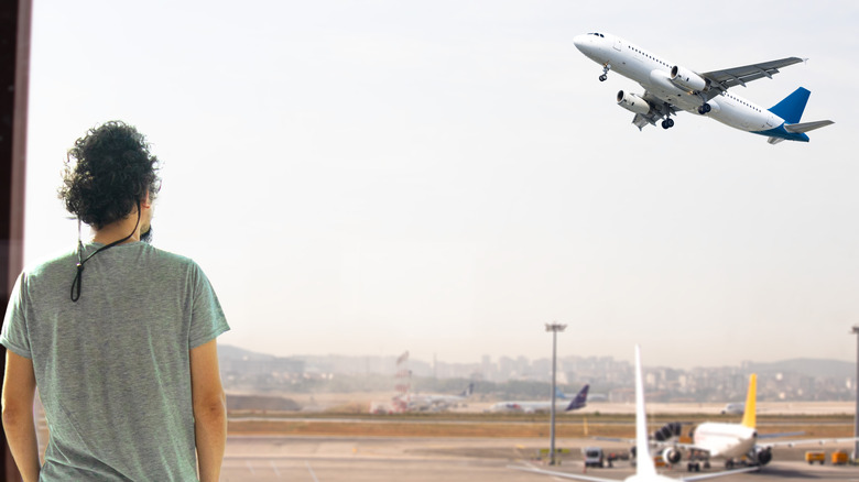 Man watching a plane take off