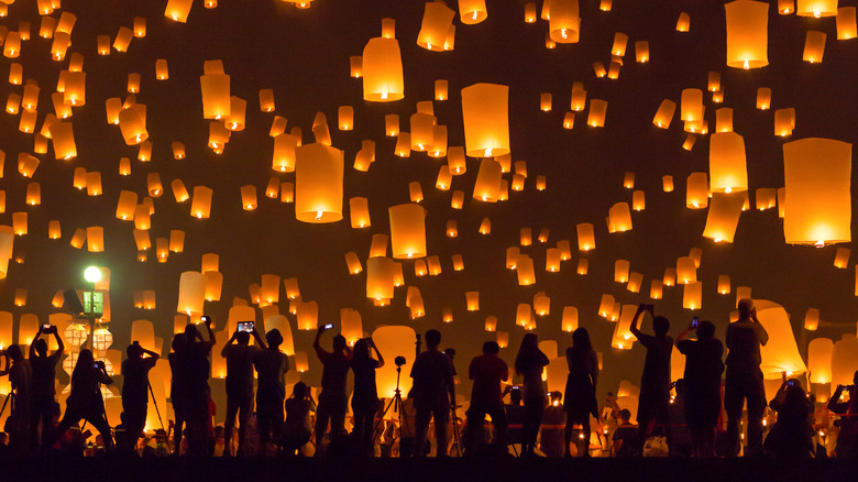 Festival goers releasing paper lanterns at night