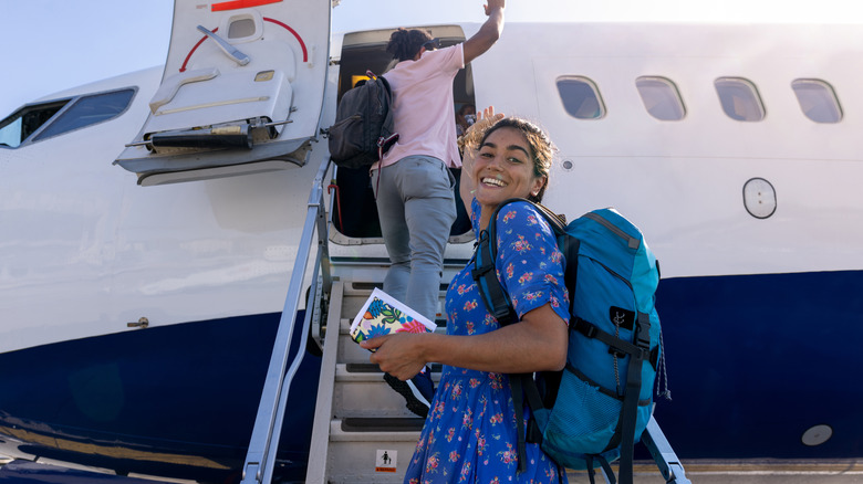 Traveler smiles while boarding a plane