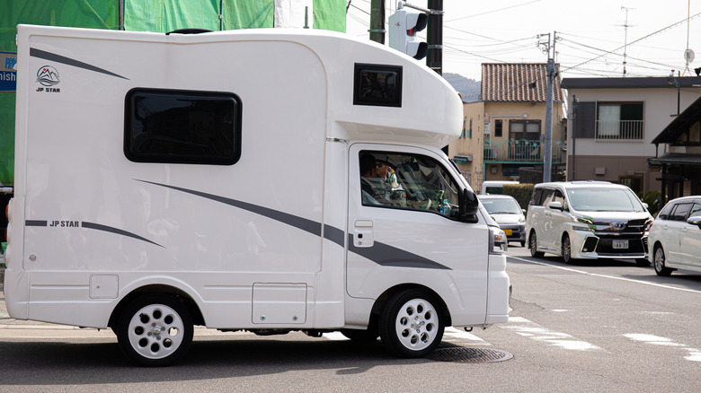 A camper van pauses at an intersection in Japan