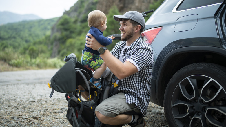 Man and baby outside vehicle