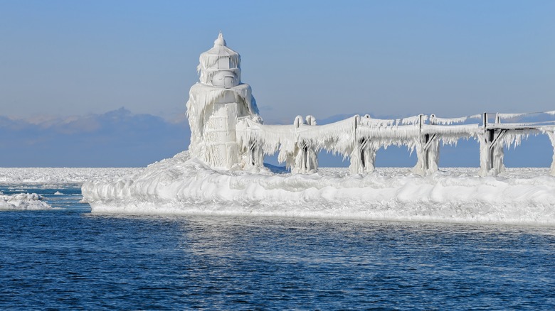 Frozen lighthouse and pier