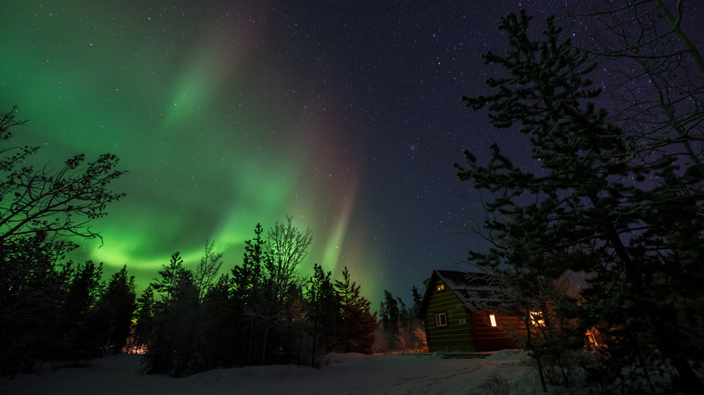 northern lights above cozy cabin