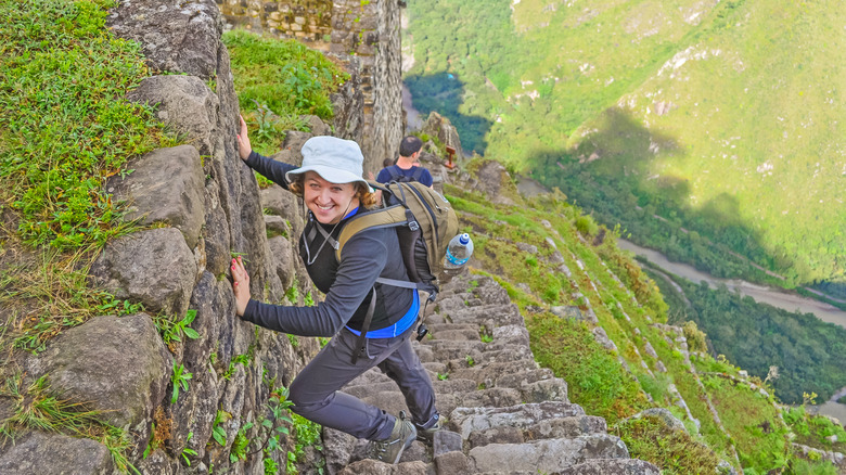 Tourist climbing steep stone staircase
