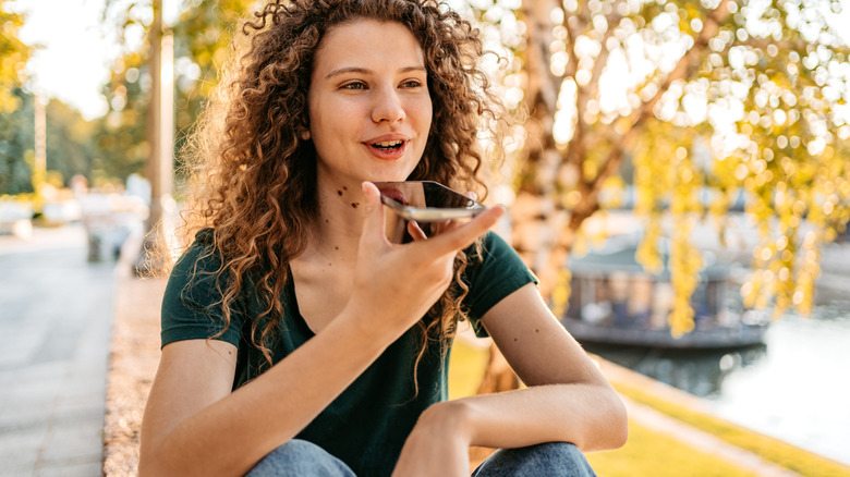 Traveler sitting outside speaking into phone