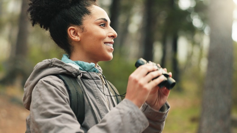 woman with binoculars in rainforest