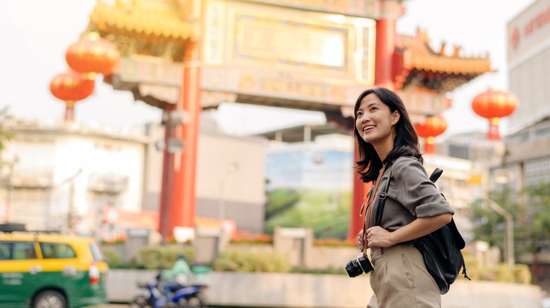 Smiling traveler near Chinese temple