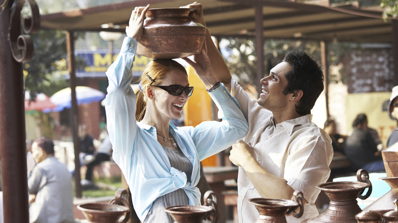 Traveler laughing with market vendor