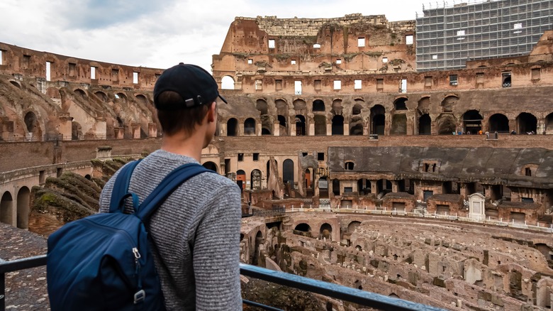 man with backpack inside Colosseum