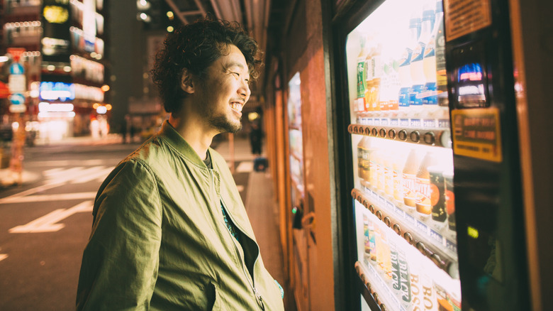 Japanese man smiling by vending machine