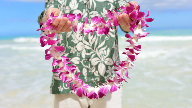 Hawaiian local offering a floral necklace as a welcome