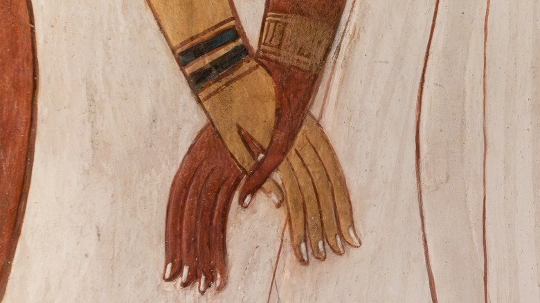 Close-up of Nefertari holding hands with a deity