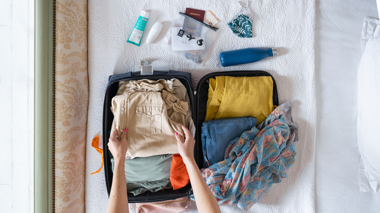 Packing carry-on with essentials and sunscreen