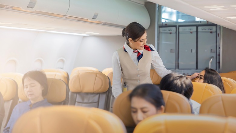 Flight attendant checking passengers