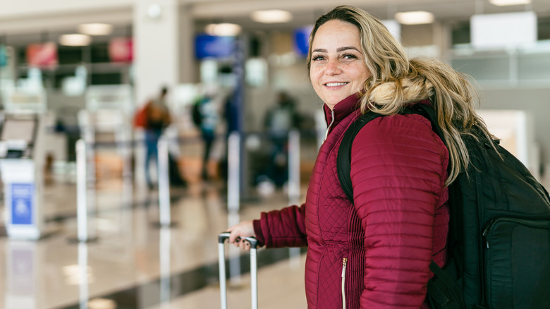 Smiling woman wearing winter coat at airport