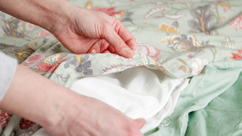 Close-up of hands changing duvet