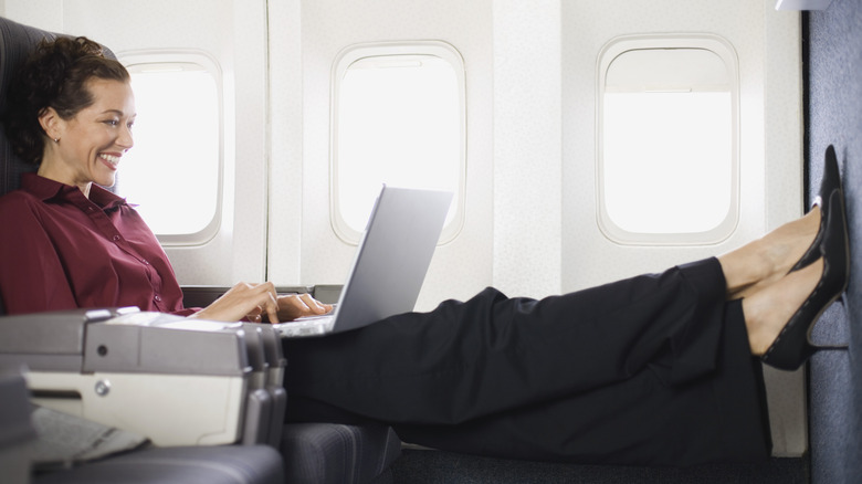 person sprawls out in first class