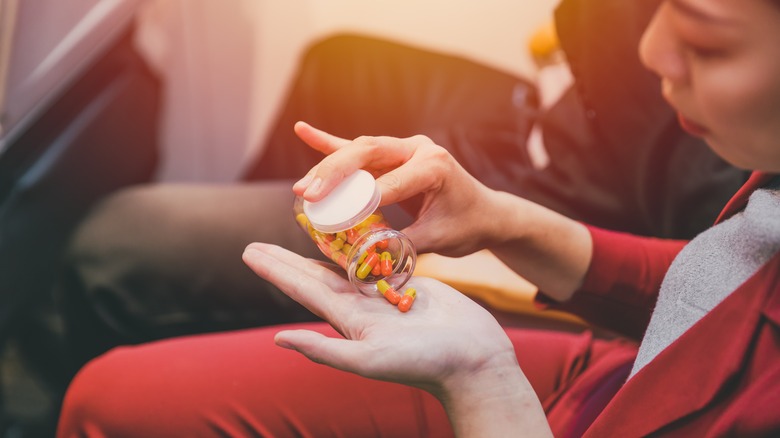 person pours pills into hand