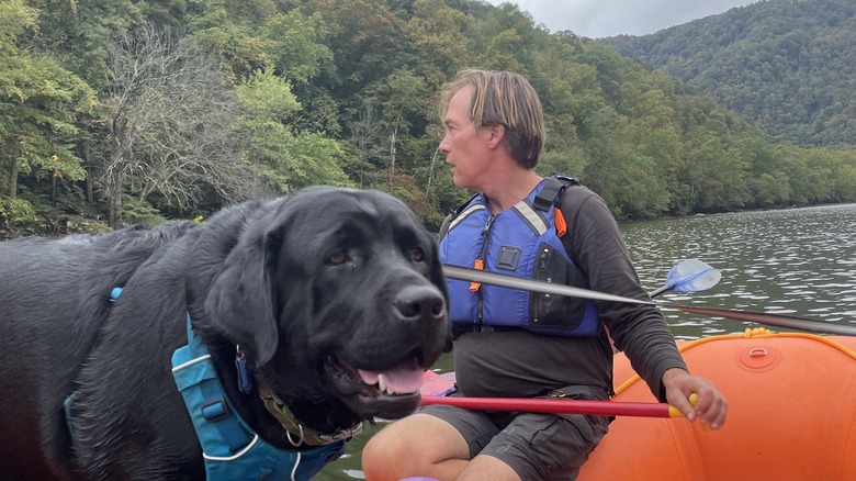 man and dog on the river