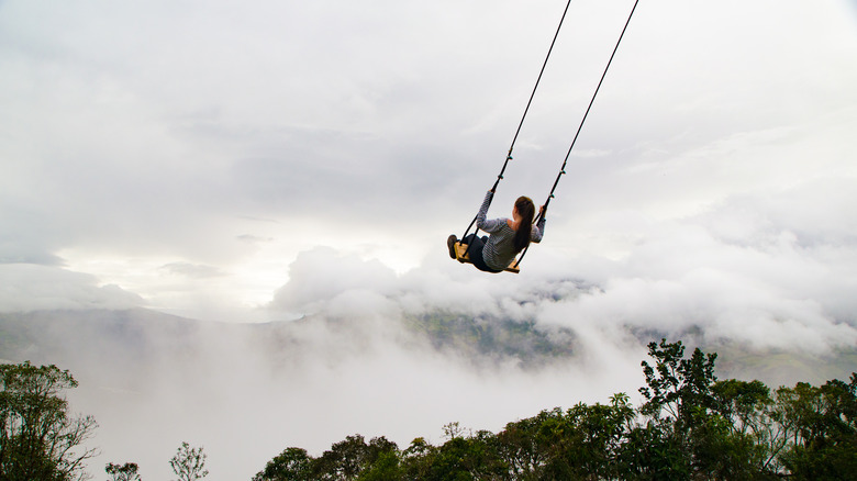 Woman swings over clouds
