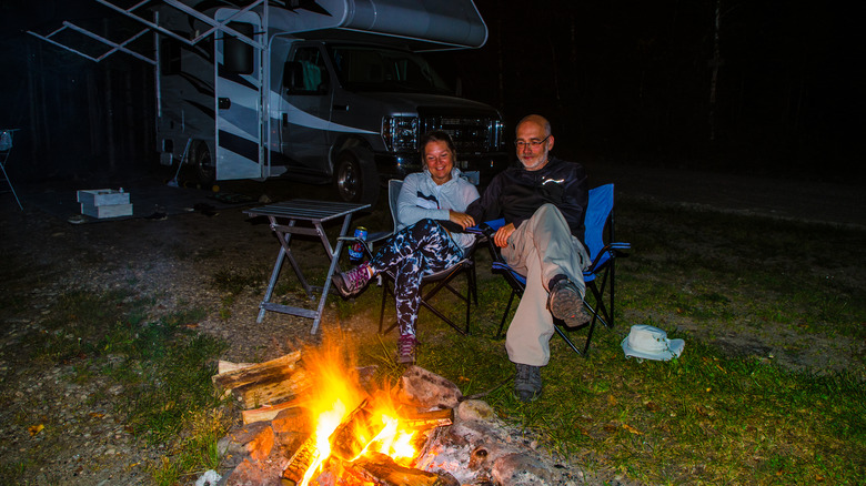 Couple RVers sitting by campfire