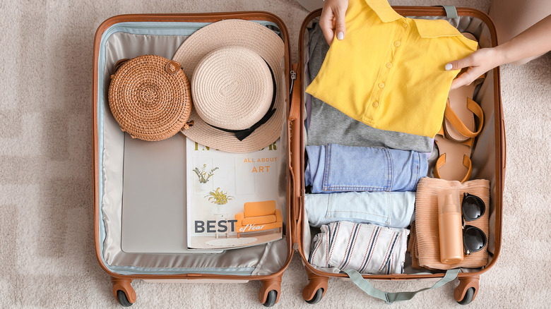 woman packing suitcase with shirt