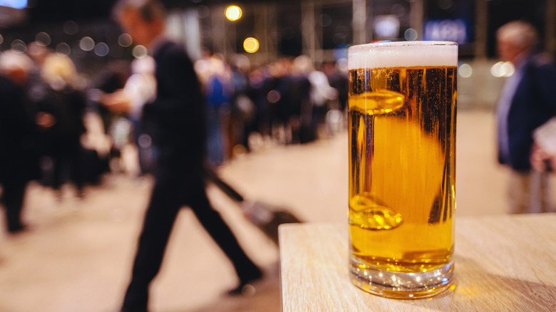 Beer pint at busy airport terminal